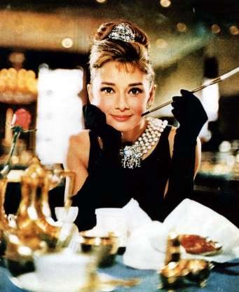 Atriz Audrey Hepburn usando vestido e par de luvas pretas