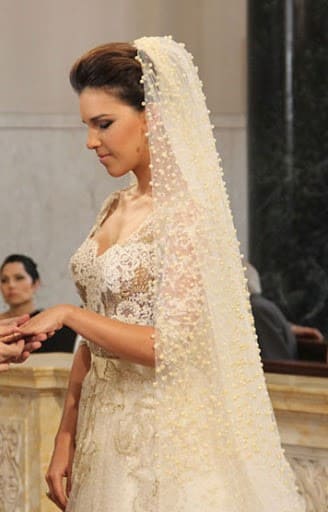 Mulher com vestido de casamento coberto de detalhes em pérolas brancas