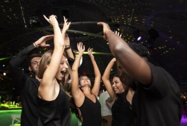 Jovens com roupas pretas se divertindo numa festa de formatura