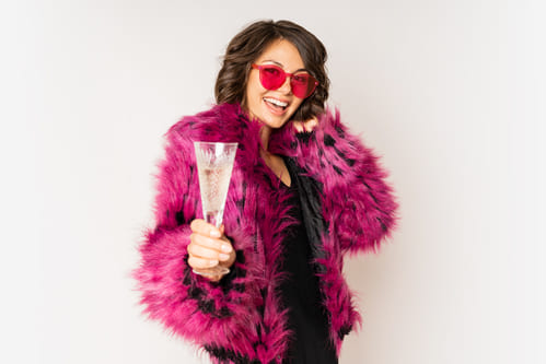 Mulher de casaco rosa no melhor estilo feminino anos 80 para festa
