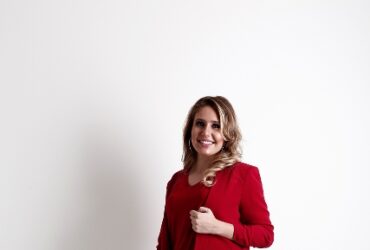 Mulher usando calça jeans e um blazer vermelho