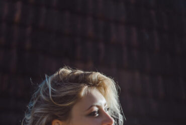 Mulher loira com look gaúcho bebendo chimarrão