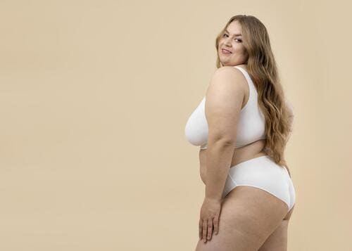 Mulher confiante demonstrando sua individualidade ao usar uma lingerie plus size branca