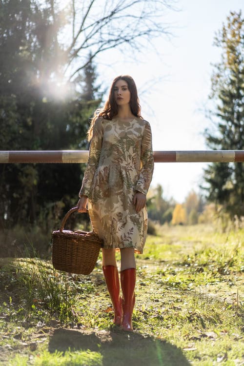 mulher usando um look de bota marrom com vestido florido no estilo hippie