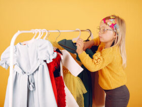 menina bonitinha organizando suas roupas infantis