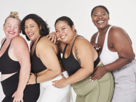 4 mulheres plus size pousando para uma foto