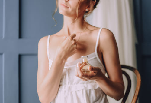 Mulher usando um perfume após acordar de uma sonho