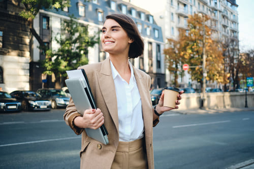 Mulher com look casual composto por conjunto de calça e blazer se preparando para uma dia de trabalho