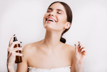 mulher aplicando perfume com feromonio após o banho