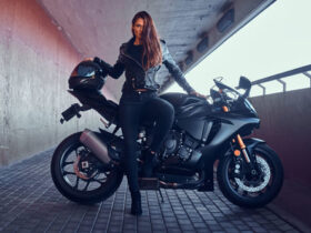 mulher encostada numa moto cpm um look preto incrível para viajar