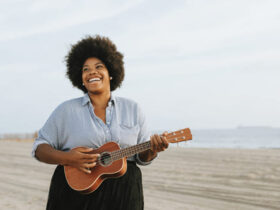 Mulher negra tocando cavaquinho na praia