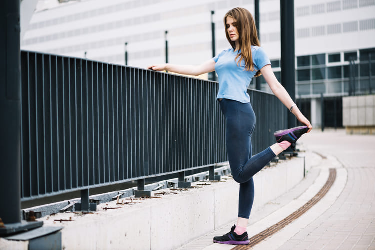 Mulher usando calça legging azul escuro e camiseta básica azul claro