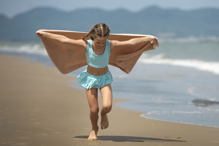meninas na areia da praia usando um conjunto de short e top na cor verde clara