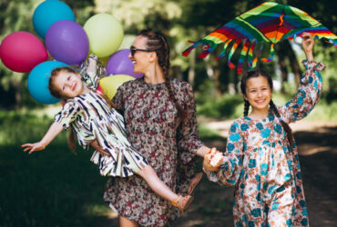 Mãe e filhas com looks floridos aproveitando uma festa infantil a tarde