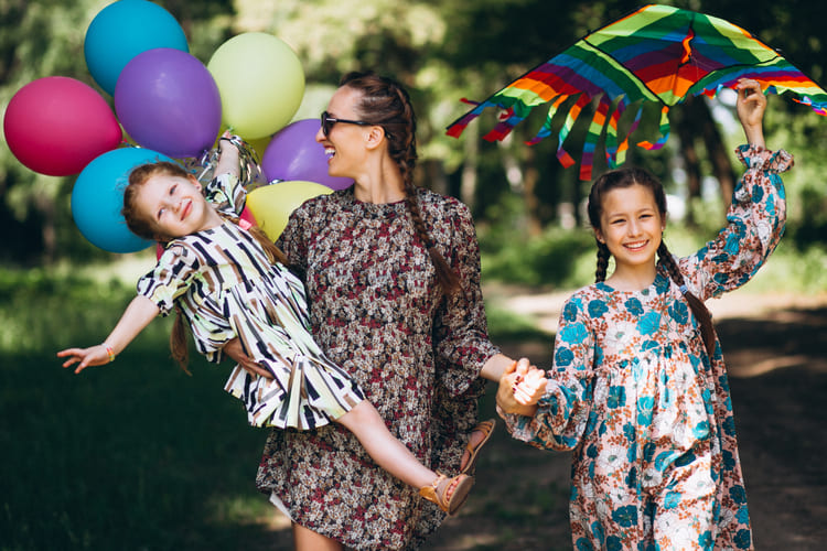 Mãe e filhas com looks floridos aproveitando uma festa infantil a tarde