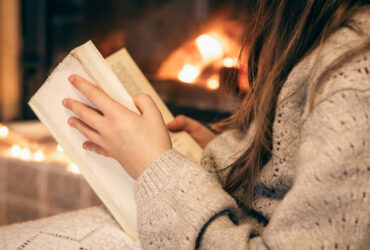 mulher usando roupas de inverno e lendo a biblia