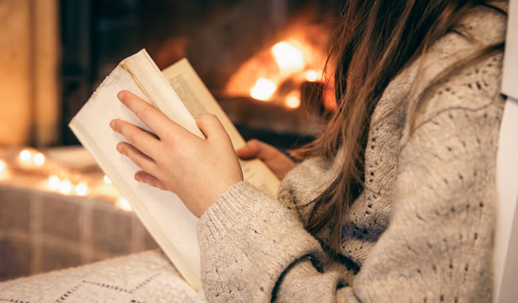 mulher usando roupas de inverno e lendo a biblia