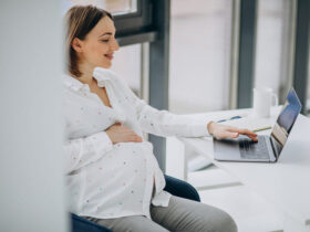 jovem mulher excutiva grávida trabalhando na frente de um notebook