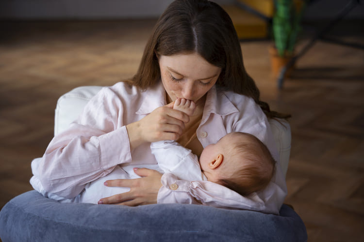 mulher descansando e amamentando filho de colo