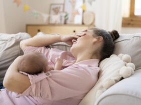 Mulher deitada cochilando e amamentando seu filho
