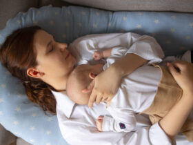 Mulher deitada descansando com o filho no colo