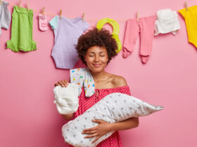 Mulher em frete a um varal com roupas de bebê penduradas