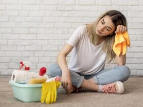 Visão frontal de uma mulher sentanta e pensando na limpeza que esta fazendo.