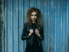 Mulher usando um look totalmente dark, com jaqueta de couro e vestido, ambos pretos