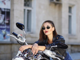 Mulher de roupas de couro preta sentada numa moto