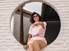 Mulher com conjunto rosa claro sentada para ensaio de fotos