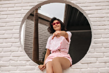 Mulher com conjunto rosa claro sentada para ensaio de fotos