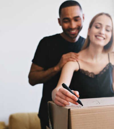 Casal organizando caixas de mudança e pensando no novo lar