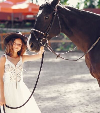 Garota com vestido branco cowntry segurando um cavalho