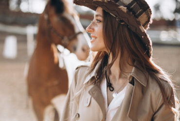 mulher com look country em frete a um cavalho
