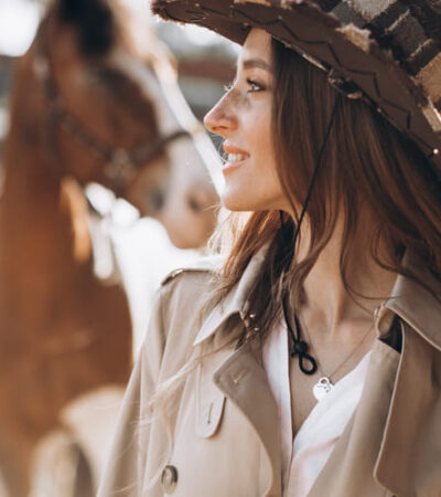 mulher com look country em frete a um cavalho