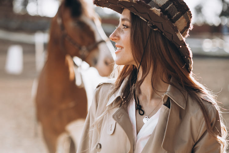 mulher com look country em frete a um cavalho