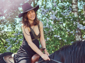 Mulher usando vestido country preto andando de cavalo